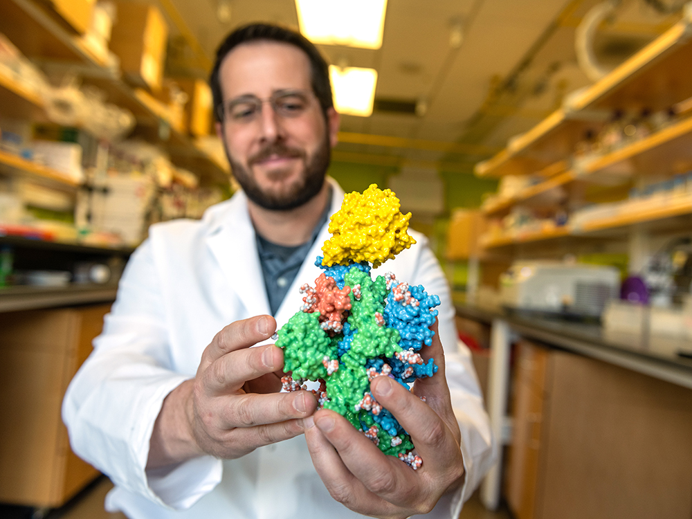 Jason McLellan holding atomic structure