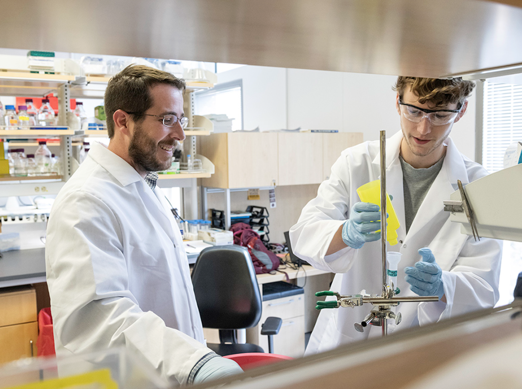 Scientists in white coats work in a lab